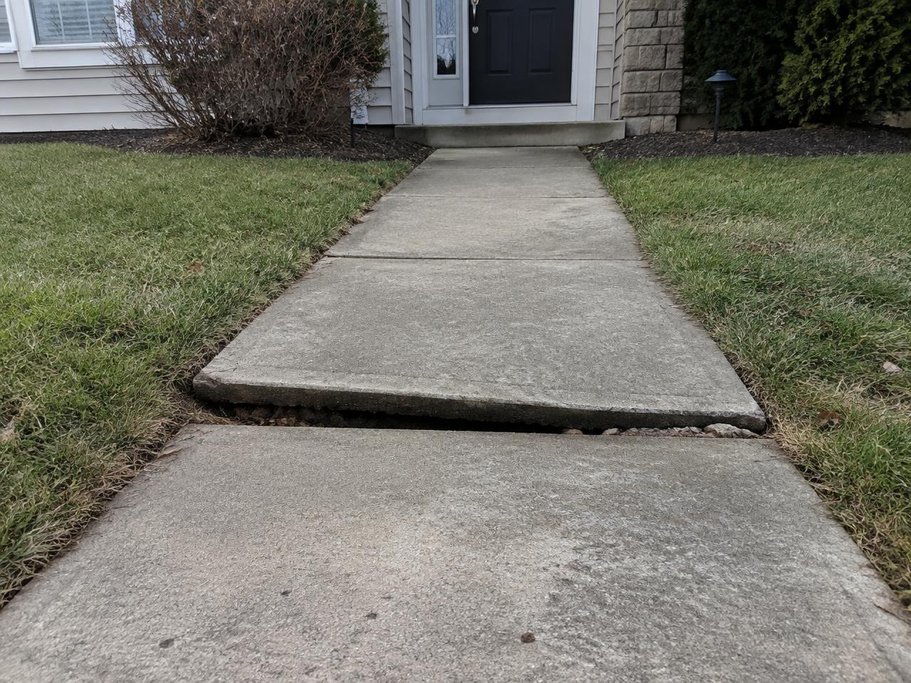 Sunken concrete walkway slab creating a trip hazard